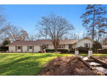 Charming single-story home featuring a well-maintained lawn, brick walkway, and a classic, neutral exterior paint scheme at 946 Scotch Dr, Gastonia, NC 28054