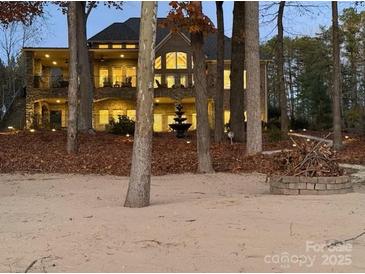 Spacious lake house featuring a sandy beach, outdoor lighting, and a charming lakeside bonfire pit at 1140 Inlet Pointe Rd, Salisbury, NC 28146