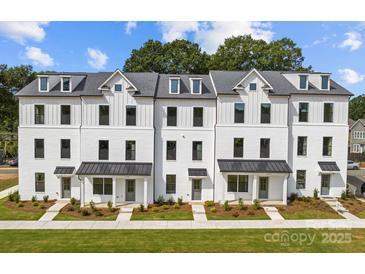 Newly constructed townhomes boast modern white facade, manicured landscaping, and a welcoming curb appeal at 5027 Layman Dr # 24, Charlotte, NC 28226