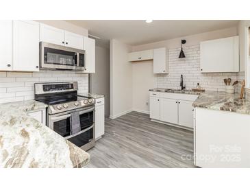 Modern kitchen with stainless steel appliances and granite countertops at 6521 Heatherbrook Ave, Charlotte, NC 28213