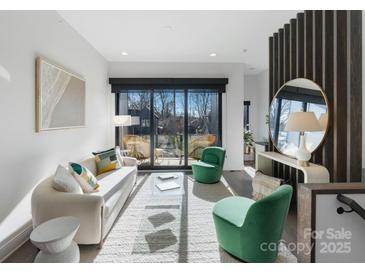 Bright living room with balcony access, hardwood floors, and modern furnishings at 819 E 36Th St, Charlotte, NC 28205