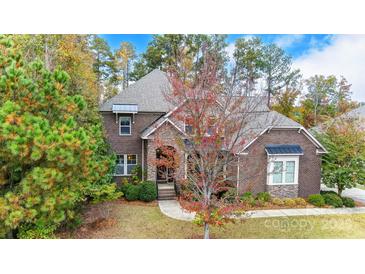 Brick home with stone accents, and a landscaped yard at 16515 Governors Club Ct, Charlotte, NC 28278