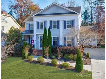 Charming two-story home with blue shutters and manicured front yard at 10029 Daufuskie Dr, Charlotte, NC 28278