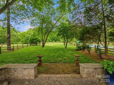 Expansive backyard featuring a lush green lawn, mature trees, and a classic wooden fence at 1655 Scotland Ave, Charlotte, NC 28207