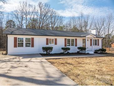 White brick ranch home with brown shutters, landscaping, and a large driveway at 1402 Springdale Park Dr, Lincolnton, NC 28092