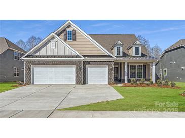 Beautiful brick home featuring a three-car garage and well-manicured lawn at 1603 Croydon St, Indian Land, SC 29707