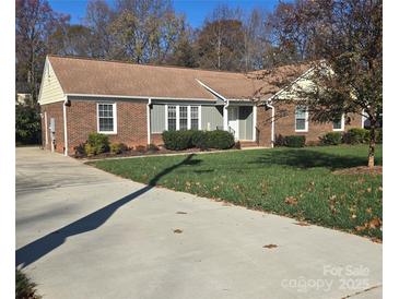 Brick ranch home with a well-maintained lawn and driveway at 433 Pamela St, Gastonia, NC 28054