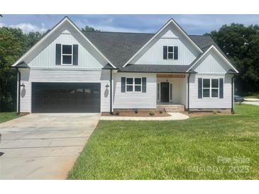 Charming two-story home featuring a black garage door, black framed windows, and a well-manicured lawn at 5037 Faith Rd, Salisbury, NC 28146