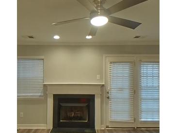 Cozy living room featuring a fireplace and a ceiling fan at 1826 Birch Heights Ct, Charlotte, NC 28213