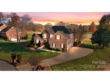 Stately brick home boasts mature landscaping, long driveway, and three-car garage at 2425 Birdie Ne Ln, Conover, NC 28613