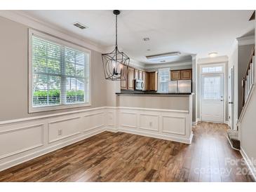 Inviting dining area featuring wood floors, decorative molding, and modern chandelier at 155 Singleton Rd, Mooresville, NC 28117