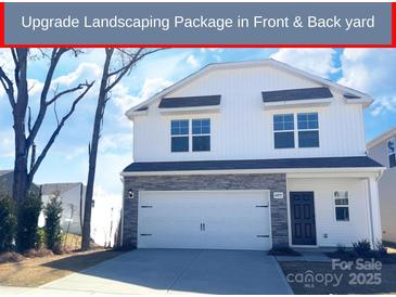 Charming two-story home featuring stone accents, a two-car garage, and manicured landscaping at 8205 Stonemere Ln, Charlotte, NC 28215
