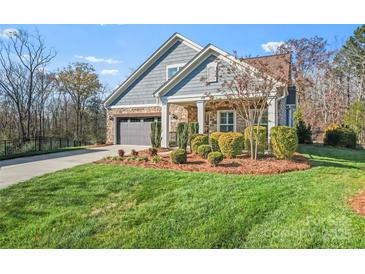 Charming home featuring manicured landscaping and a stone and gray siding exterior at 1236 Avalon Pl, Matthews, NC 28104