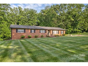 Charming brick home featuring manicured lawn and lush, mature landscaping at 216 Delview Dr, Cherryville, NC 28021