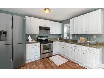 Updated kitchen featuring stainless steel appliances, granite countertops, and white cabinetry at 2630 Druid Hills Way, Charlotte, NC 28206