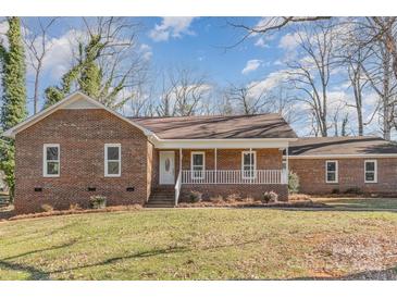 Brick ranch house with front porch and landscaped lawn at 4408 Shea Ln, Mint Hill, NC 28227