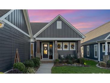 Gray two-story home with a welcoming front porch and landscaping at 112 Sisters Cove Ct, Mooresville, NC 28117