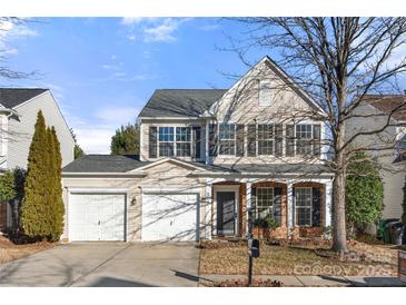 Two-story house with beige siding, two-car garage, and a covered porch at 11131 Cypress View Dr, Charlotte, NC 28262