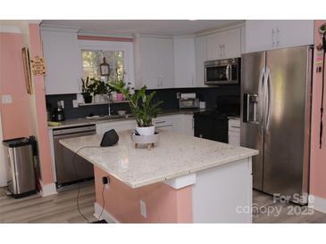 Modern kitchen with stainless steel appliances and island at 5824 Crossing King Dr, Charlotte, NC 28212