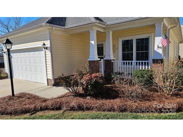 Charming yellow ranch home with a white garage door and landscaped front yard at 1001 Jessica Ln, Matthews, NC 28104