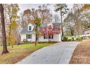 Charming Cape Cod-style home with a long driveway and mature trees providing shade and curb appeal at 110 Yorktowne St, Fort Mill, SC 29715