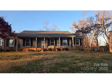 Brick ranch home with covered porch and landscaped yard at 1308 Princeton Ave, Gastonia, NC 28054