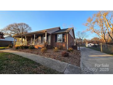 Side view of brick ranch home with driveway and landscaping at 1308 Princeton Ave, Gastonia, NC 28054