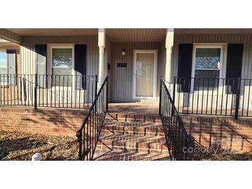 Inviting front porch features brick steps, black iron railings, and classic columns at 1308 Princeton Ave, Gastonia, NC 28054