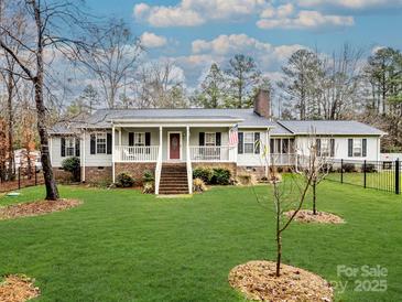 Ranch style home with covered porch, landscaped lawn, and fenced yard at 2430 Lazy Oak Dr, Lancaster, SC 29720