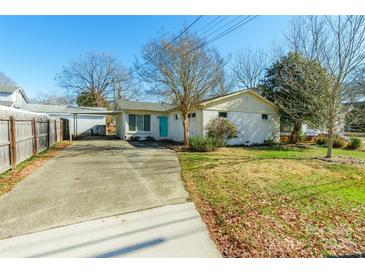 Ranch home with carport, fenced yard, and mature trees at 549 Spring Sw St, Concord, NC 28025