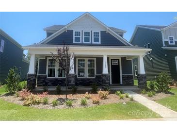 Charming home with a covered front porch, stone accents, and beautiful landscaping at 9605 Pointer Rd # 78, Huntersville, NC 28078