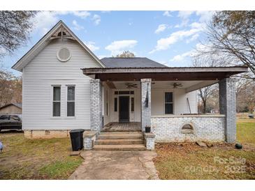 Charming white house with a front porch and mature trees at 302 Charlotte St, York, SC 29745