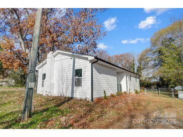 Newly renovated house exterior boasts a clean, white exterior and landscaped yard at 105 Center St, Kings Mountain, NC 28086