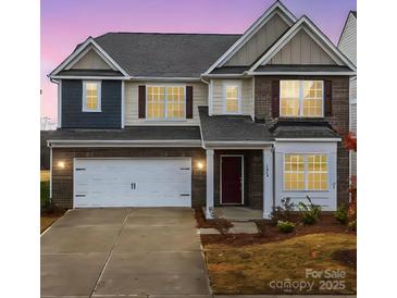 Two-story home with brick and siding exterior, two-car garage, and landscaping at 3064 Virginia Trail Ct, Fort Mill, SC 29715