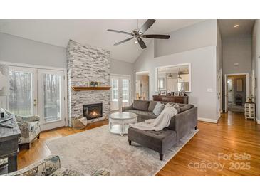 Inviting living room featuring a stone fireplace and hardwood floors at 180 Sink Farm Rd, Mooresville, NC 28115