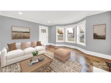 Bright living room with hardwood floors, large windows, and a comfortable white sofa at 306 S Jones Ave, Rock Hill, SC 29730