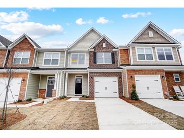 Brick front exterior of townhome with 2-car garage and landscaping at 4153 Black Ct # 173, Harrisburg, NC 28075