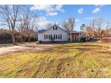 Ranch home with blue metal roof, covered porch, and large yard at 10310 Stokes Ferry Rd, Gold Hill, NC 28071