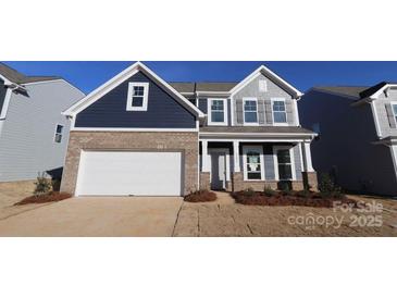 Two-story home with navy blue and gray siding, brick accents, and a white garage door at 2608 Clipper Nw Ct, Concord, NC 28027