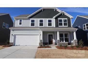 Two-story home featuring a covered entry, a two-car garage, and professional landscaping at 2612 Clipper Nw Ct, Concord, NC 28027