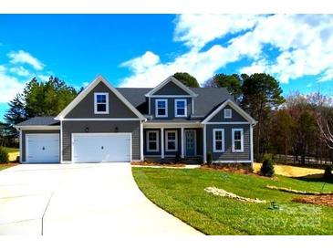 Charming two-story home with a well-manicured lawn and a two-car garage at 143 Dabbling Duck Cir, Mooresville, NC 28117