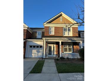 Charming brick home with a covered front porch, attached garage, and well-maintained landscaping at 18731 Ramsey Cove Dr # 72, Cornelius, NC 28031