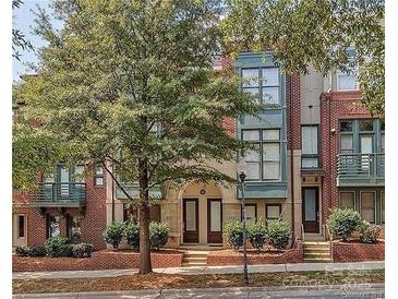 Attractive brick townhome with two-story design, arched entry, and landscaping at 658 E 10Th St, Charlotte, NC 28202