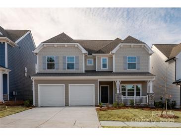 Charming two-story home featuring a covered porch, well-maintained lawn, and a two-car garage at 18024 Wilbanks Dr, Charlotte, NC 28278