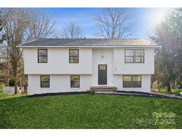 Newly renovated two-story house with a white brick exterior and a landscaped lawn at 607 King Arthur Dr, Gastonia, NC 28056