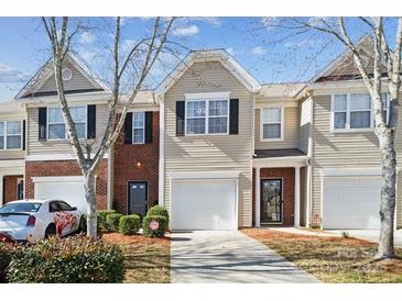 Charming townhome with a well-maintained front yard and attached garage, featuring a mix of brick and vinyl siding at 7122 Abbotts Glen Dr, Charlotte, NC 28212