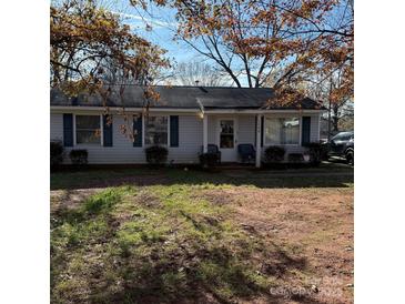 Cozy single-story home with blue shutters and mature trees in a residential neighborhood at 1406 Milan Rd, Charlotte, NC 28216