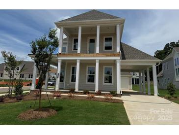 Beautiful two-story home features a large front porch with white columns and attached carport at 7392 Deer Hollow Rd # 27, Sherrills Ford, NC 28673