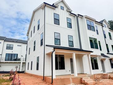 New construction townhome with white siding, black trim, covered front porch and stylish modern architecture at 13013 Moon Rd # 41, Charlotte, NC 28277