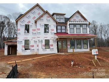 Newly constructed two-story home with red roof and wrap-around porch at 2007 Kendall Dr # 6, Wesley Chapel, NC 28173